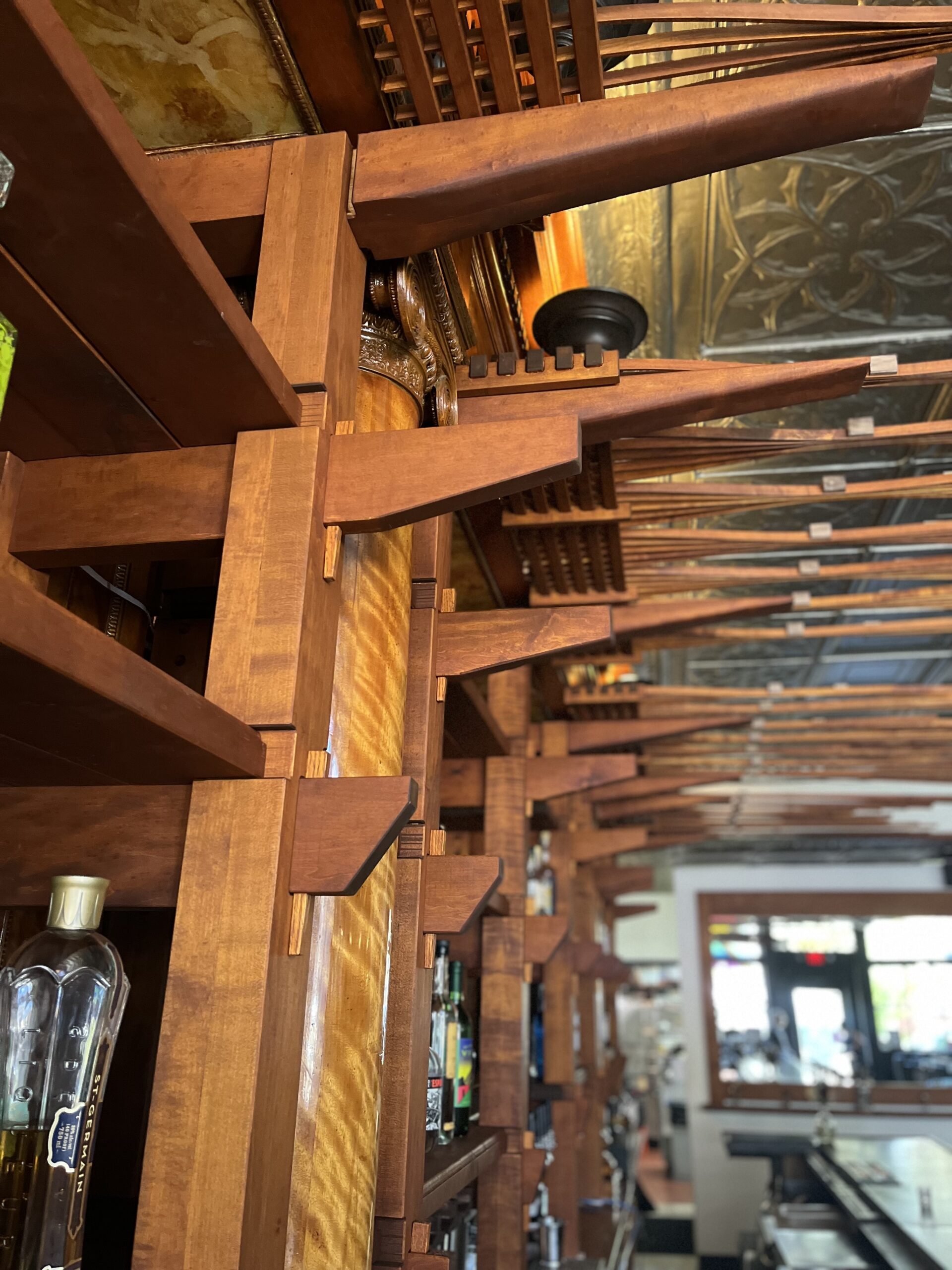 Full bar shelving profile. Keyed mortise and tenons, knock down joinery. Close-up of cascading shelf supports that decrease in size from top to bottom, creating a curved effect.