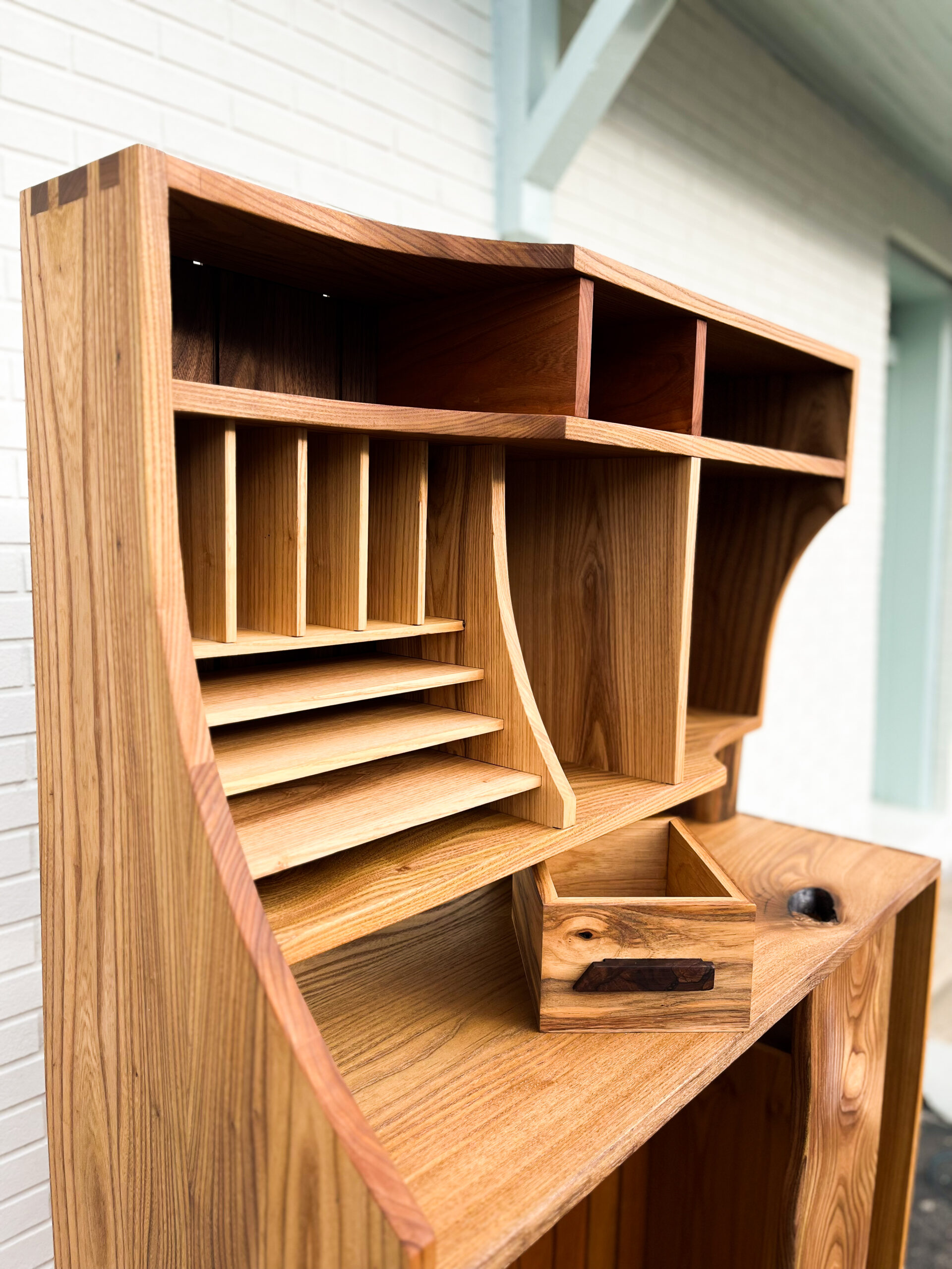 Profile of letterbox slots. Side view of cabinet with an apparent swoop that is featured on the upper left casework that extends from the top to the center landing.