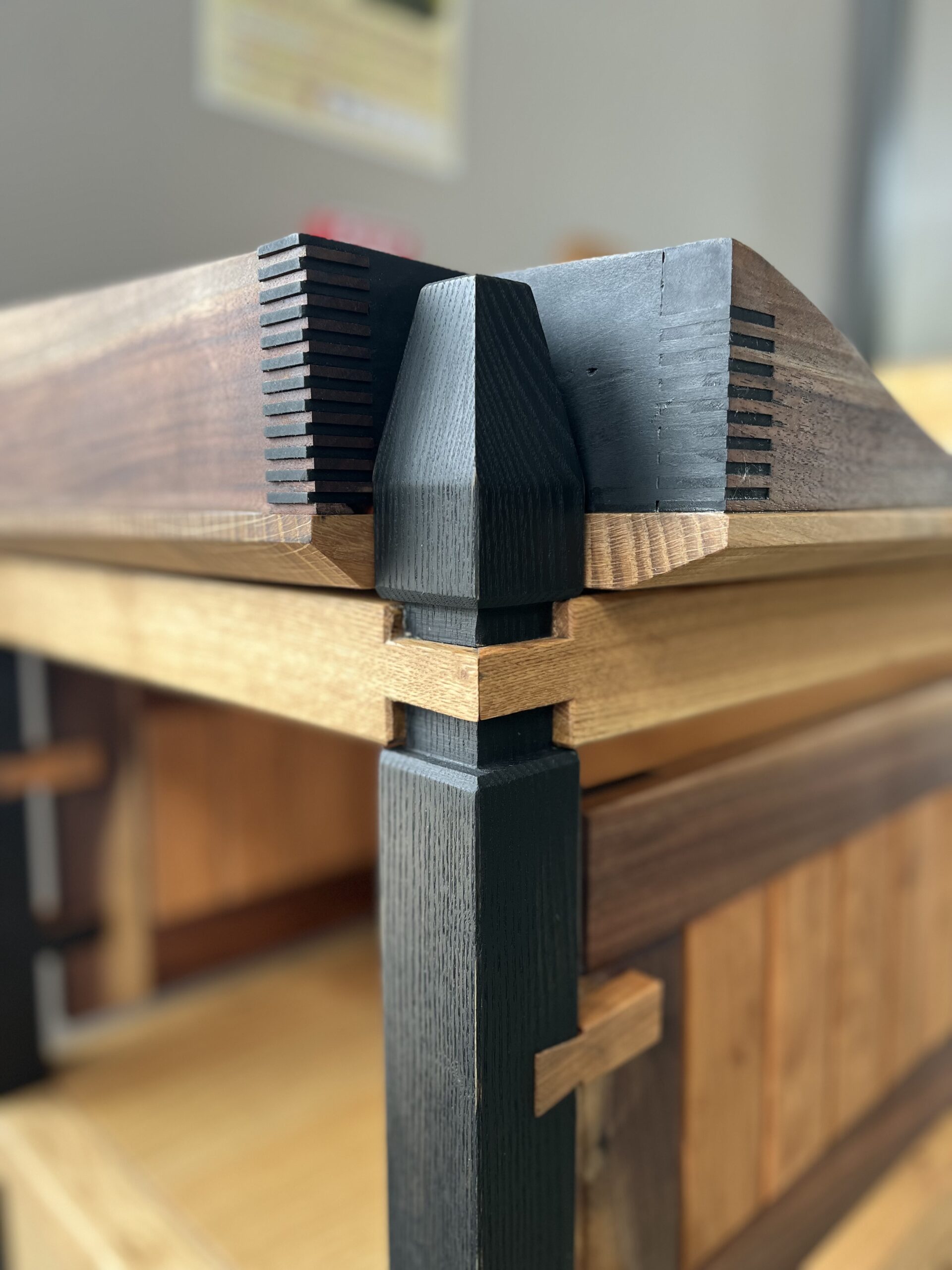 Mitered exposed tenon on kitchen server station top corner. Detail of front leg meeting the top of the piece. Finger joints and mitered through mortise and tenon.  