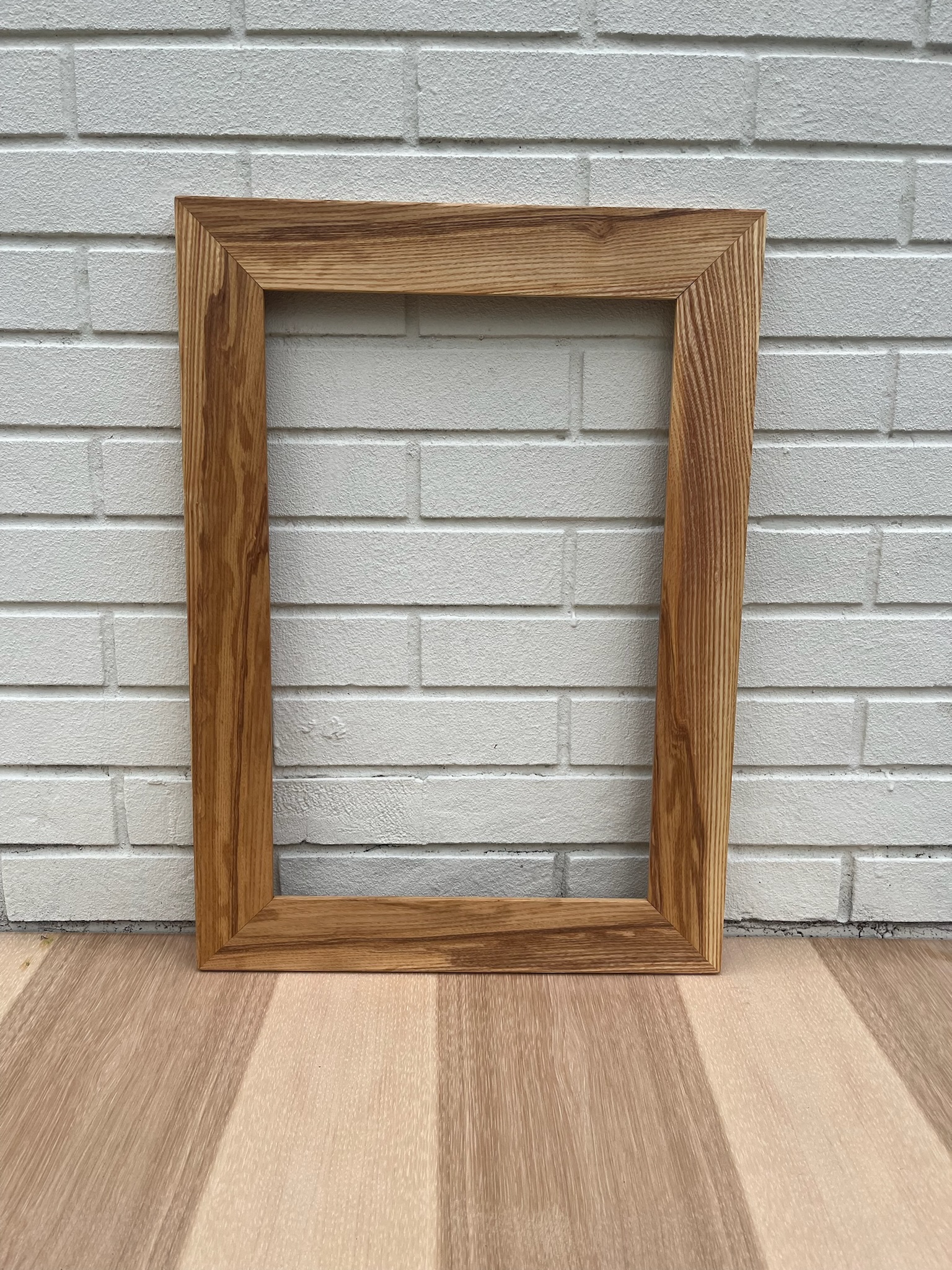 Butternut wood frame. Distinct wood grain with various gradation of natural colors. Head on view.