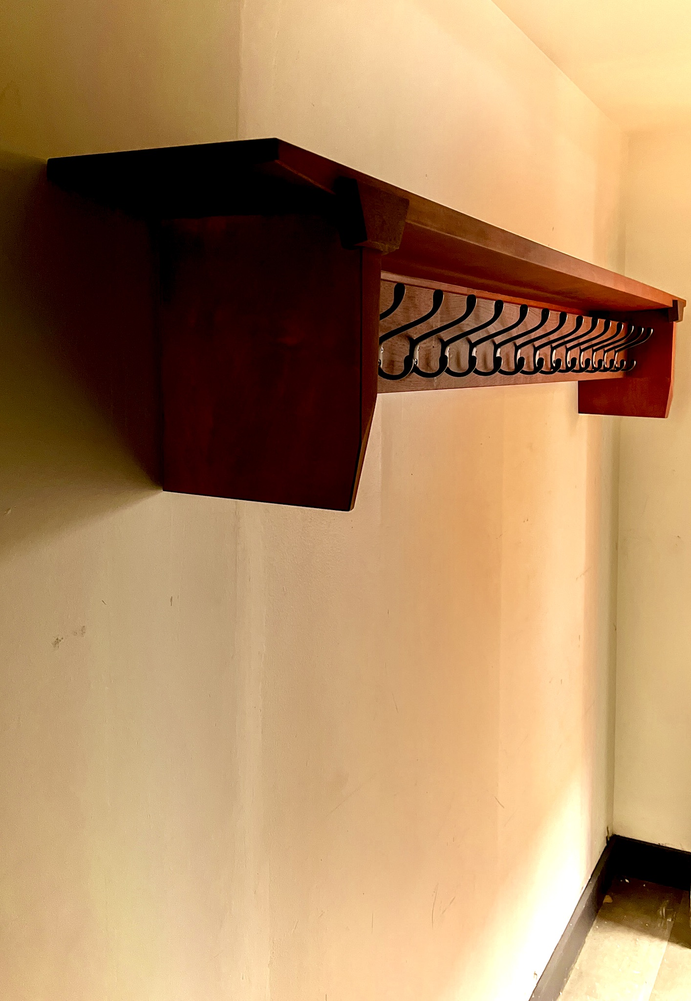 Eye level view of coatrack hanging on a wall. Subtle angles highlighted by natural light filtering into the space. 