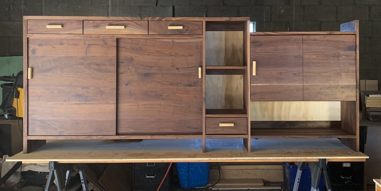 Bar cabinet. Panel doors, matching walnut grain, white ash handles. Sapwood, gradation of natural wood grain colors are featured on the middle drawer.