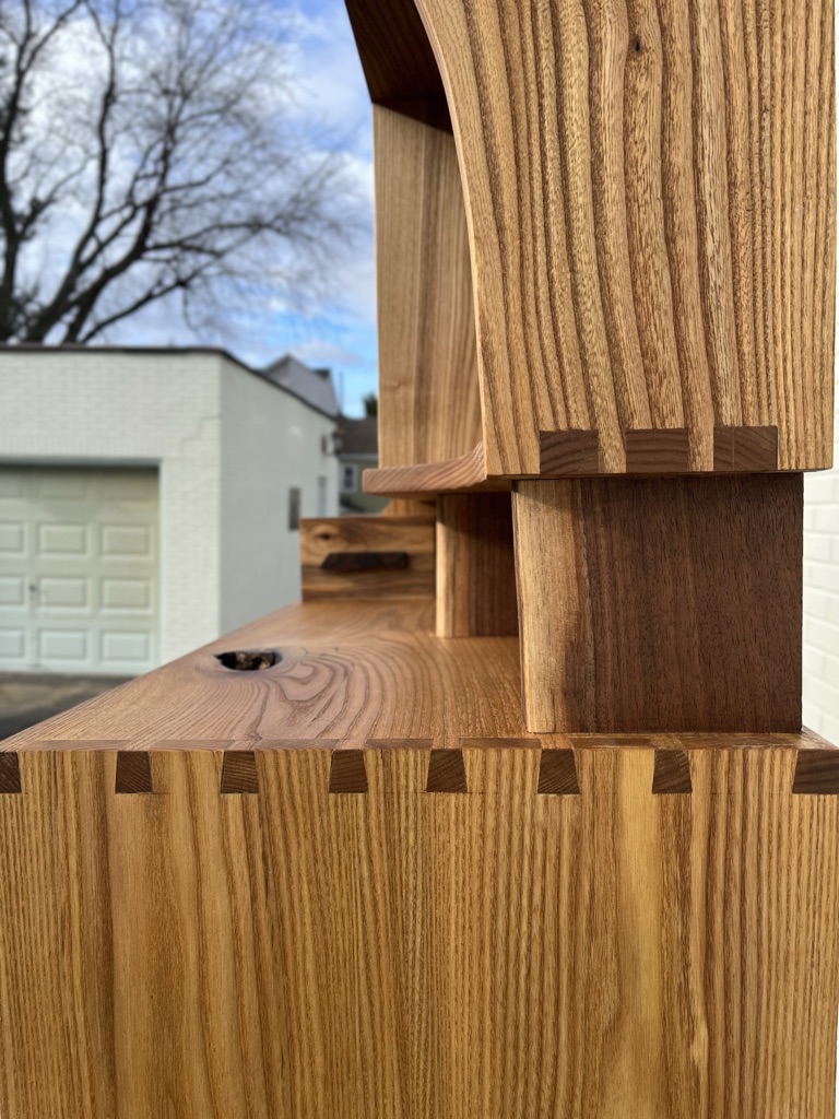 Box joints and dovetails on top and bottom of entrway case. Black walnut with sapwood supports of upper case. Natural knot is featured.