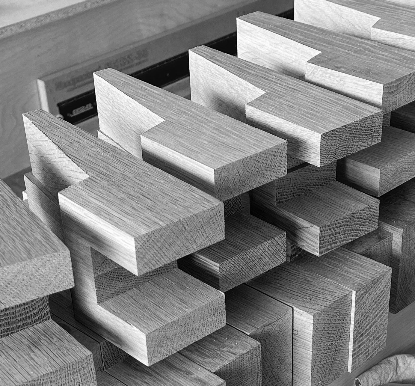 Hand-cut blocks of oak wood stacked with showcasing end grain on the base of them. 