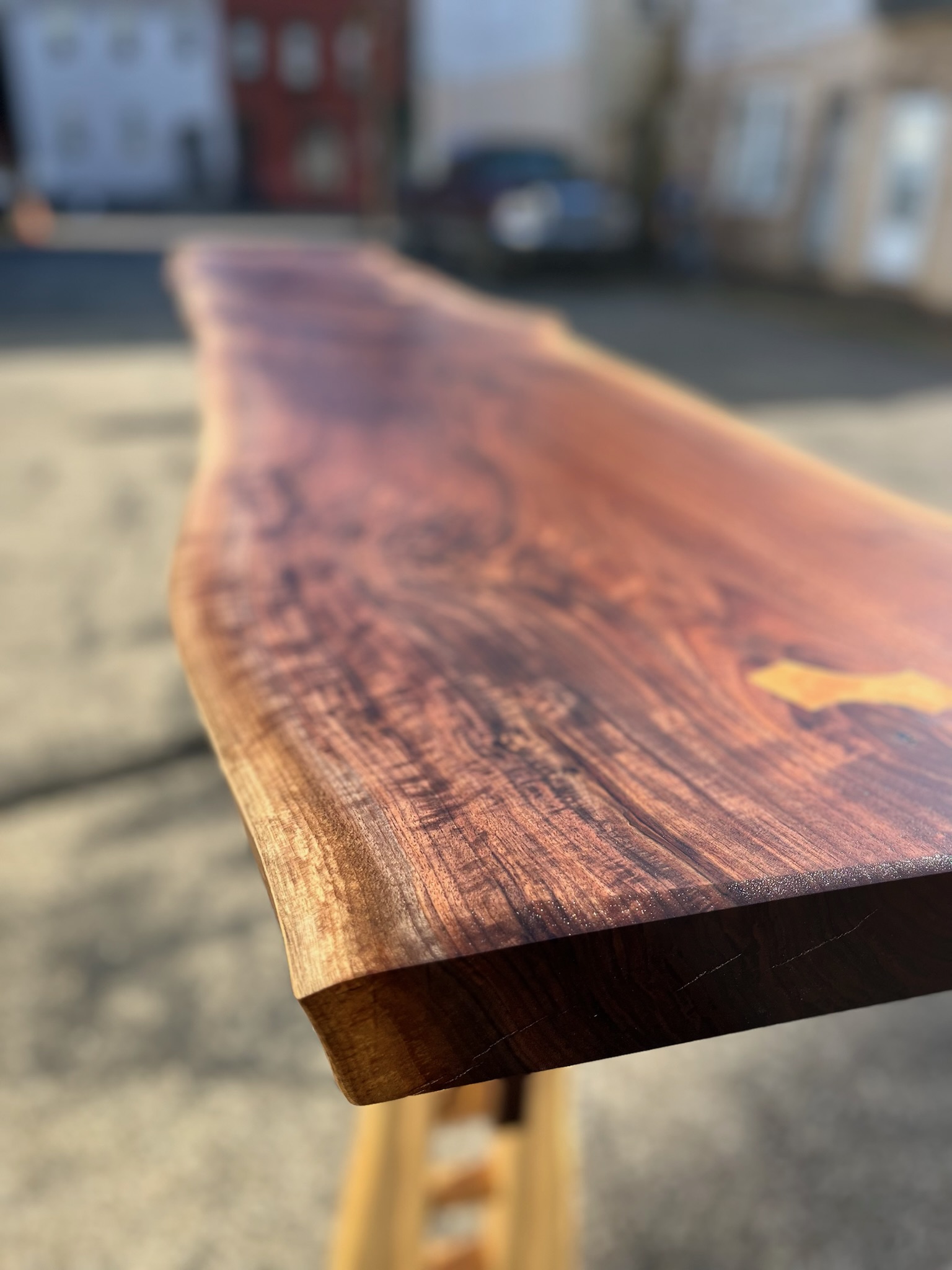 walnut tabletop edge exhibiting shimmer or curling, which is naturally occurring in this species.