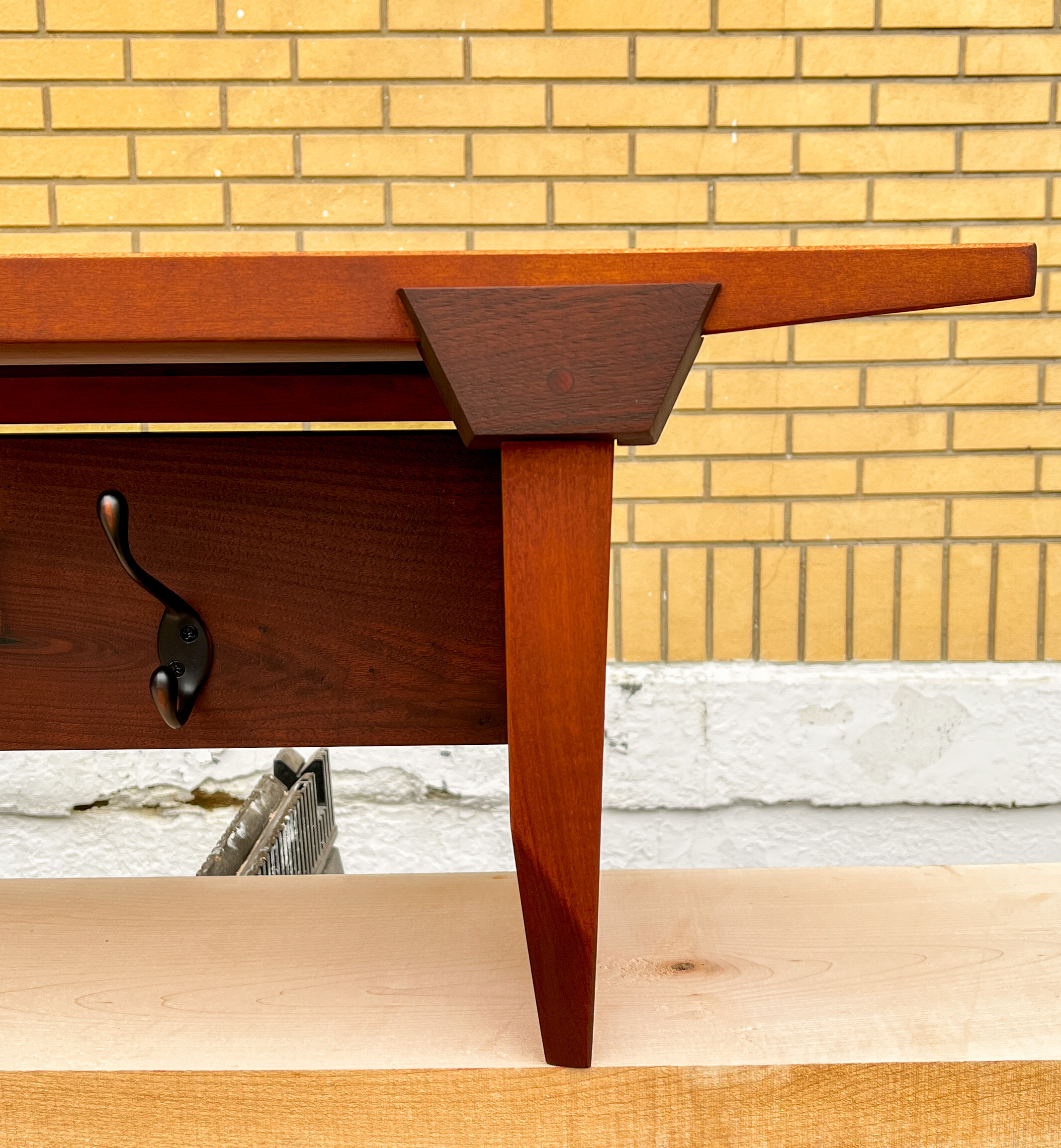 Right end of a coat rack. A Keystone shapened accent and beveled side are center of image.