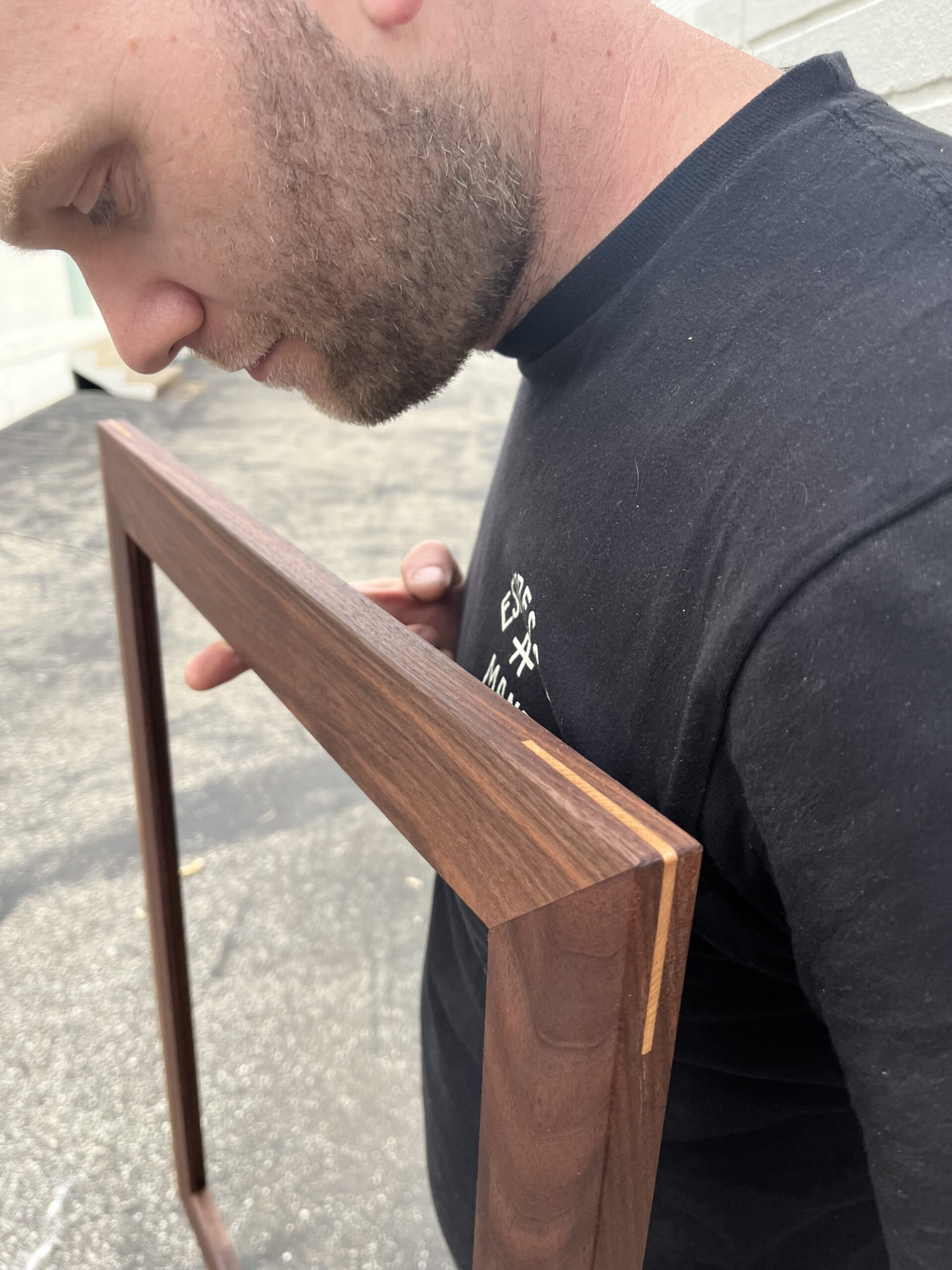 man holding splined, mitered walnut frame.