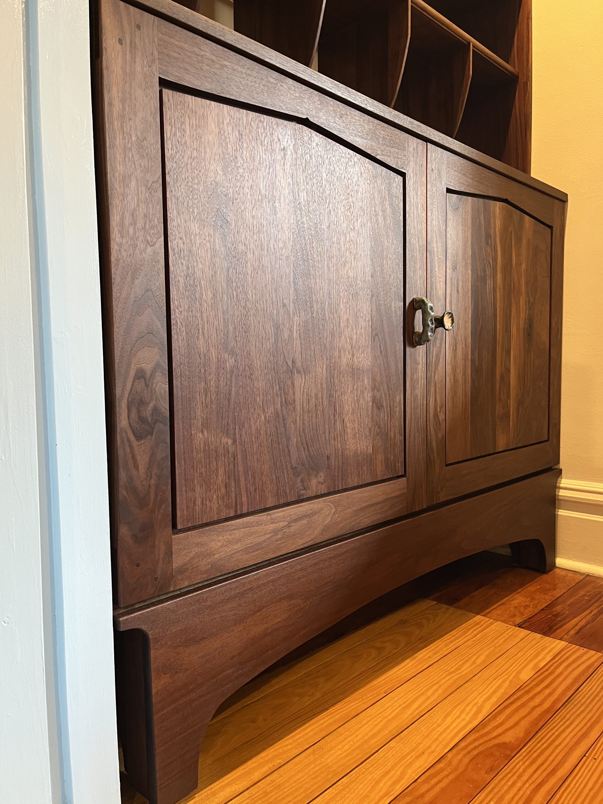 cabinet portion of a larger bookcase fitted perfectly into a recessed niche of a living room. 