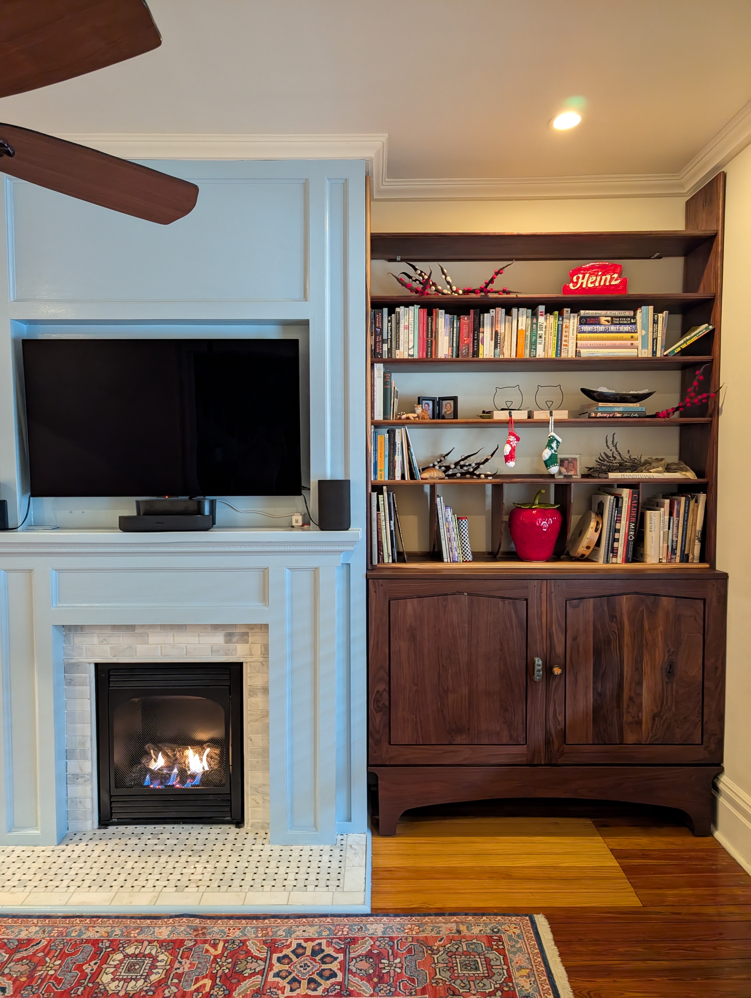 living room fireplace with a walnut bookcase, shelving to the immediate right.